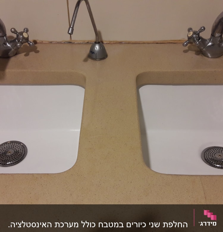 שני כיורים עם ברזים כפולים על משטח שיש
